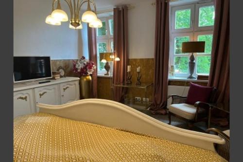 um quarto com uma cama, uma cadeira e janelas em Studio-Apartment Rektor Suite 26 am Saseler Markt renoviert em Hamburgo