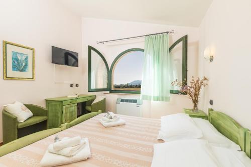 una camera con due letti e una finestra di Hotel Janas a Tertenìa