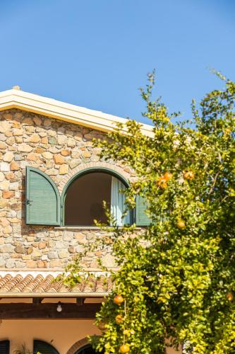 a window on the side of a building with an orange tree at Hotel Janas in Tertenìa