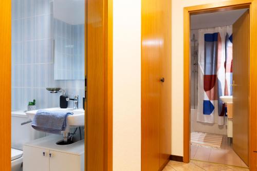 een badkamer met een wastafel en een spiegel bij 4.5 locali magnifica vista lago e parking pubblico in Mendrisio