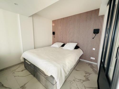 1 dormitorio pequeño con 1 cama con sábanas blancas en Sea View Bellamare next Palais Festival, en Cannes