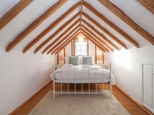 a bedroom with a white bed in a attic at Twosome in Halesworth