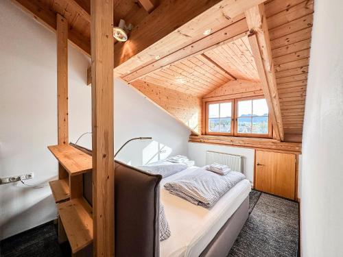 a small bedroom with a bed in a wooden house at FeWo "Sonnenschein" Oberreute in Oberreute
