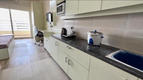 eine Küche mit einer Theke mit einem Waschbecken und einem Fenster in der Unterkunft Paramount Golfforeste in Greater Noida