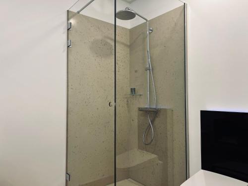 a shower with a glass door in a bathroom at Château Lecusse - La Grande Roche - Hôtel, Spa, Boutique & Restaurant in Broze