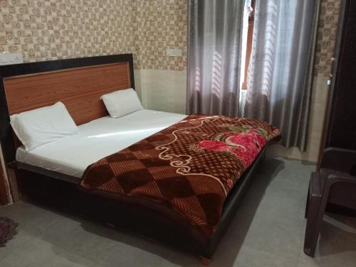 a bedroom with a bed with a wooden headboard at Shri mad bhagavat mandir in Vrindāvan