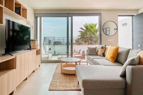 a living room with a couch and a tv at CASA LA BOTAVARA - Pool & Beach in Abades