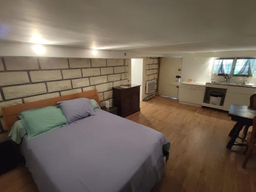 1 Schlafzimmer mit einem großen weißen Bett und einer Küche in der Unterkunft Studio privé dans maison in Le Plessis-Trévise