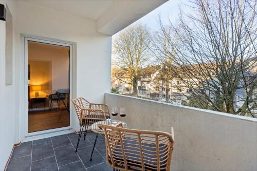een balkon met stoelen en uitzicht op een tafel bij Villa trifft Zeche by Cordis Sky für bis zu 7 Personen 5 Minuten zur Messe Essen und zum Hauptbahnhof Essen in Essen