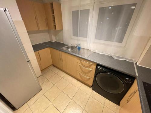 a small kitchen with a sink and a dishwasher at Central Apartment in Bedford