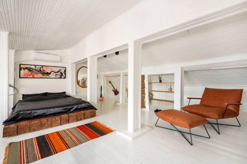 1 dormitorio con 1 cama y 1 silla en White Studio Near To Istiklal Street With Sea View, en Estambul