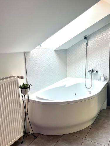 a large white bath tub in a bathroom at Chill apartman in Budakalász