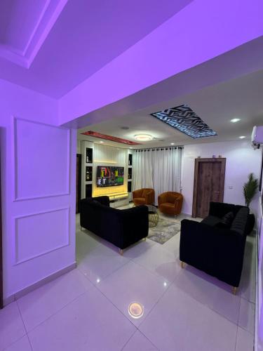 a living room with purple ceilings and couches at SAMBEST Home in Lagos