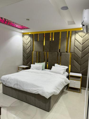 a bedroom with a large bed with white sheets at SAMBEST Home in Lagos
