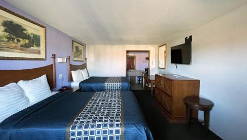 a hotel room with two beds and a desk at Royal Inn Linden in Linden