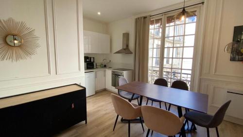 - une cuisine avec une table à manger et des chaises dans l'établissement Cocooning appartement à côté Champs-Elysée, à Paris