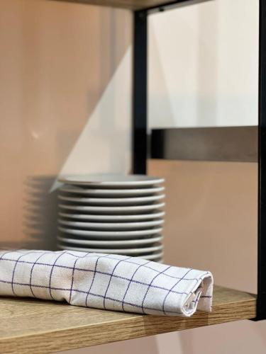 une pile de assiettes et une serviette sur une table dans l'établissement Cocooning appartement à côté Champs-Elysée, à Paris