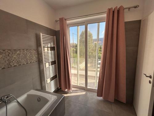 a bathroom with a tub and a large window at Villa Maïa in Dhrámia
