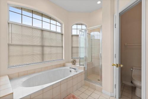 a bathroom with a tub and a shower and a toilet at Sunrise Oaks in Port Orange