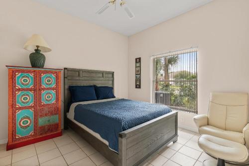 a bedroom with a bed and a chair and a window at Sunrise Oaks in Port Orange