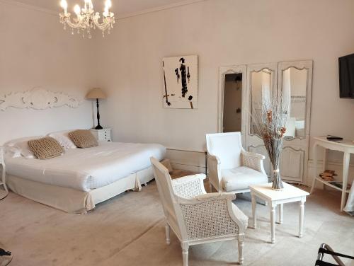a bedroom with a bed and a chair and a chandelier at Château Les 4 Saisons in Saint-Cirgues-sur-Couze