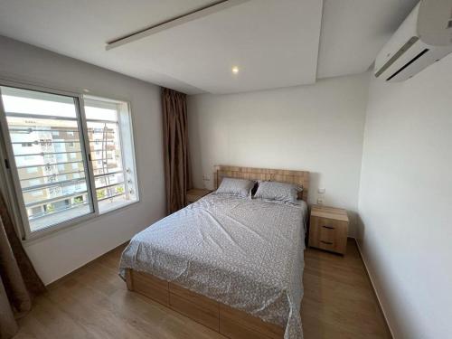um quarto com uma cama e uma janela em Appart de luxe 27 ILOT9 em Oujda
