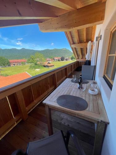 a balcony with a table and glasses of wine at Block's Lounge in Krün