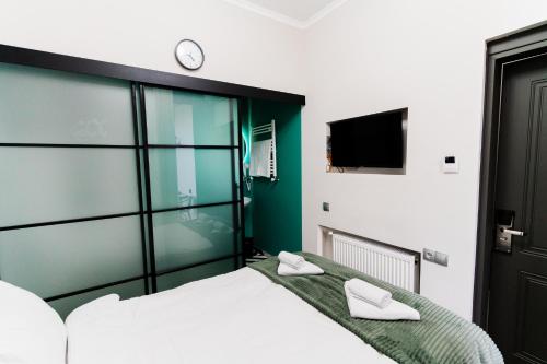 a bedroom with a bed and a clock on the wall at Trinity Hotel in Tbilisi City