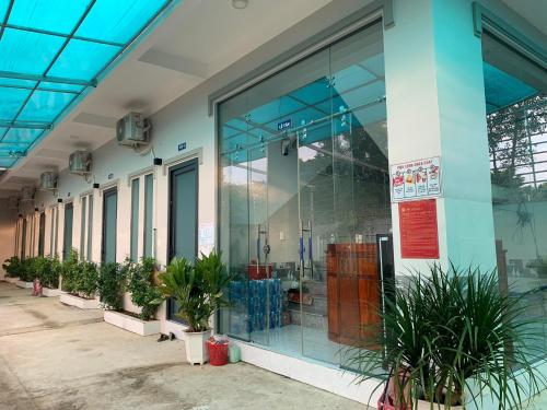 una tienda con ventanas de cristal y macetas en Nhà nghỉ Quốc Khánh, en Dồng Xoài