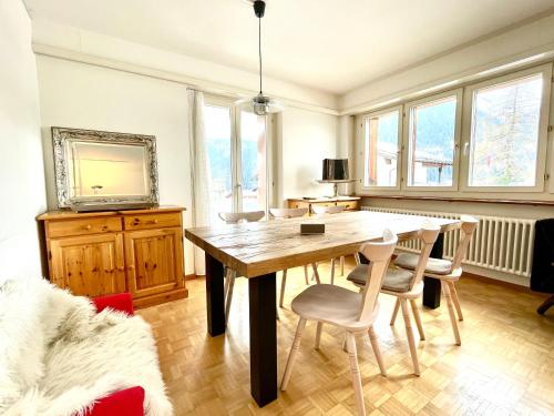 a dining room with a wooden table and chairs at Swiss Alpine Hideaway in Sedrun