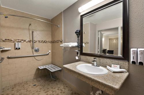 a bathroom with a sink and a shower and a mirror at Red Roof Inn Los Angeles - Bellflower in Bellflower