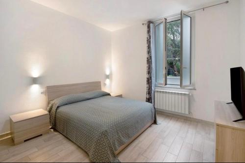 a bedroom with a bed and a tv and a window at Casavienna app A2 in Varazze