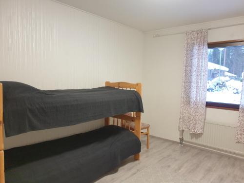a bedroom with two bunk beds and a window at Saunallinen rivitalohuoneisto B5 59m2 in Säviä