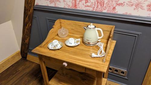 a small wooden table with a tea kettle on it at Manoir du Kasteelveld in Cassel