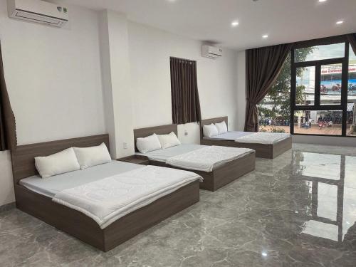 - une chambre avec 2 lits et une grande fenêtre dans l'établissement NGOC PHUNG HOTEL, à Ban Blech