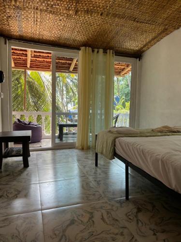 1 dormitorio con cama y ventana grande en Palm Breeze Villas, en Palolem