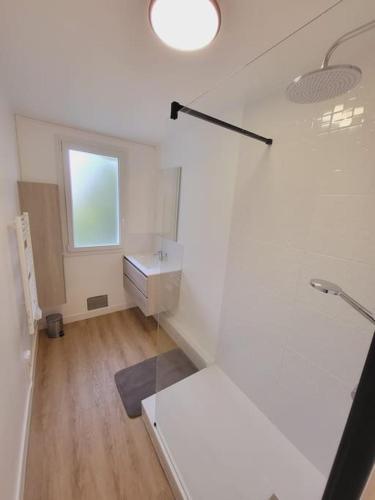 ein weißes Bad mit einem Waschbecken und einem Fenster in der Unterkunft Logement grand confort in Laval