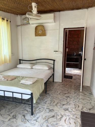 1 dormitorio con 2 camas y puerta al baño en Palm Breeze Villas, en Palolem