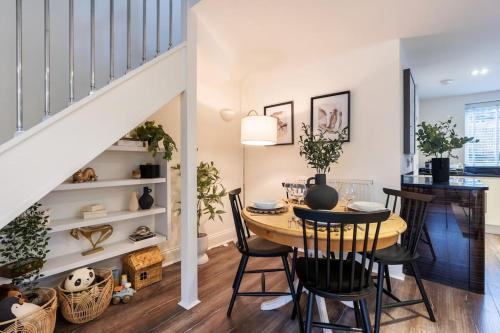 a dining room with a table and chairs and a staircase at Tranquil Riverfront Oasis at High Bridge Court in Knaresborough