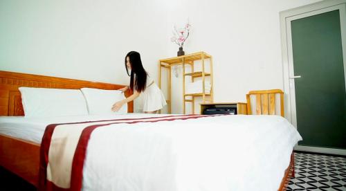 a woman is standing next to a bed at BA DŨNG VILLA COFFEE - ĐẢO PHÚ QUÝ - Bình Thuận in Cu Lao Thu
