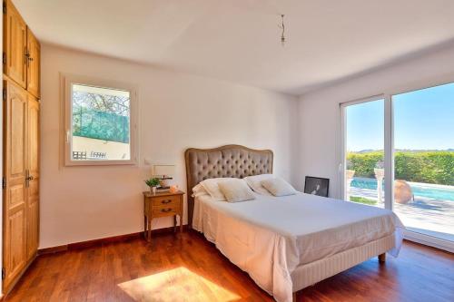 une chambre avec un lit et une grande fenêtre dans l'établissement 10mn de Cannes, villa entière de 150m2., au Cannet