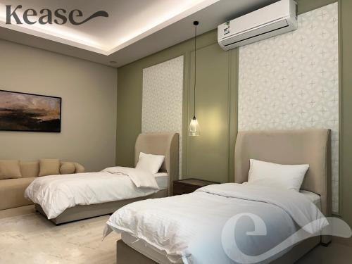 a bedroom with two beds and a heater on the wall at Kease Al-Mutamarat A-13 Timeless History GX22 in Riyadh
