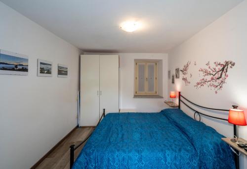una camera con letto blu e armadio di Rossana Apartment Lago Maggiore a Baveno