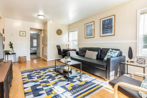 a living room with a couch and a table at Cozy House 10min to Monuments and DC by CozySuites in Arlington