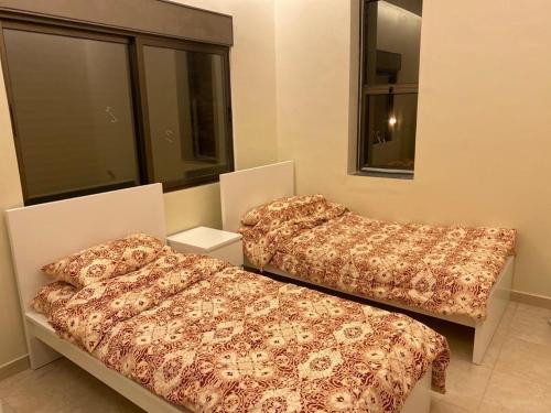 two beds sitting in a room with a window at Madaba hills Villa in Dulaylat al Ḩamāʼidah