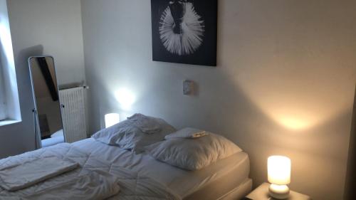 um quarto com uma cama com duas luzes em Victor Hugo 3 G sa pizza offerte em Aurillac