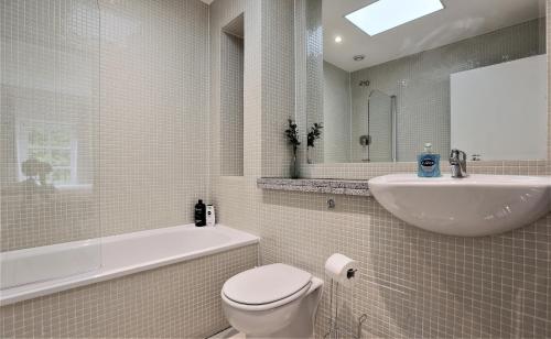 een badkamer met een toilet, een wastafel en een bad bij Period Character with Modern Comforts In Monkstown in Blackrock