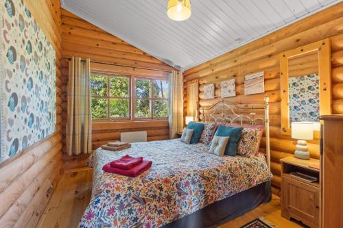 a bedroom in a log cabin with a bed at Bluebells in Highampton