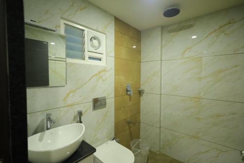 a bathroom with a sink and a shower at Arctic Business Hotel in Cochin