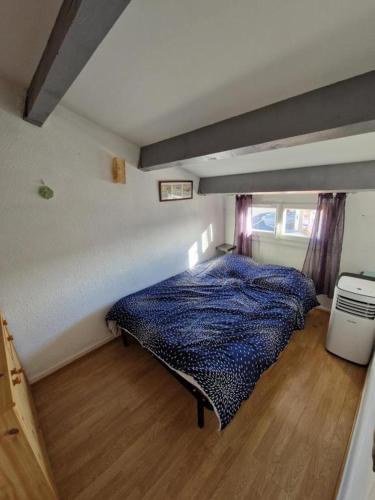 une chambre avec un lit dans le coin d'une pièce dans l'établissement villa T2 cabine 500m de la plage, à Portiragnes